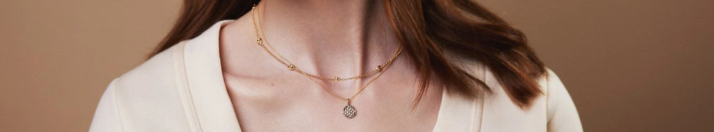 Woman's neck wearing layers of gold necklaces