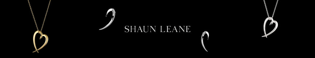 Black background, Shaun Leane logo in white at the centre, one earring on either side and one necklace on either side further out