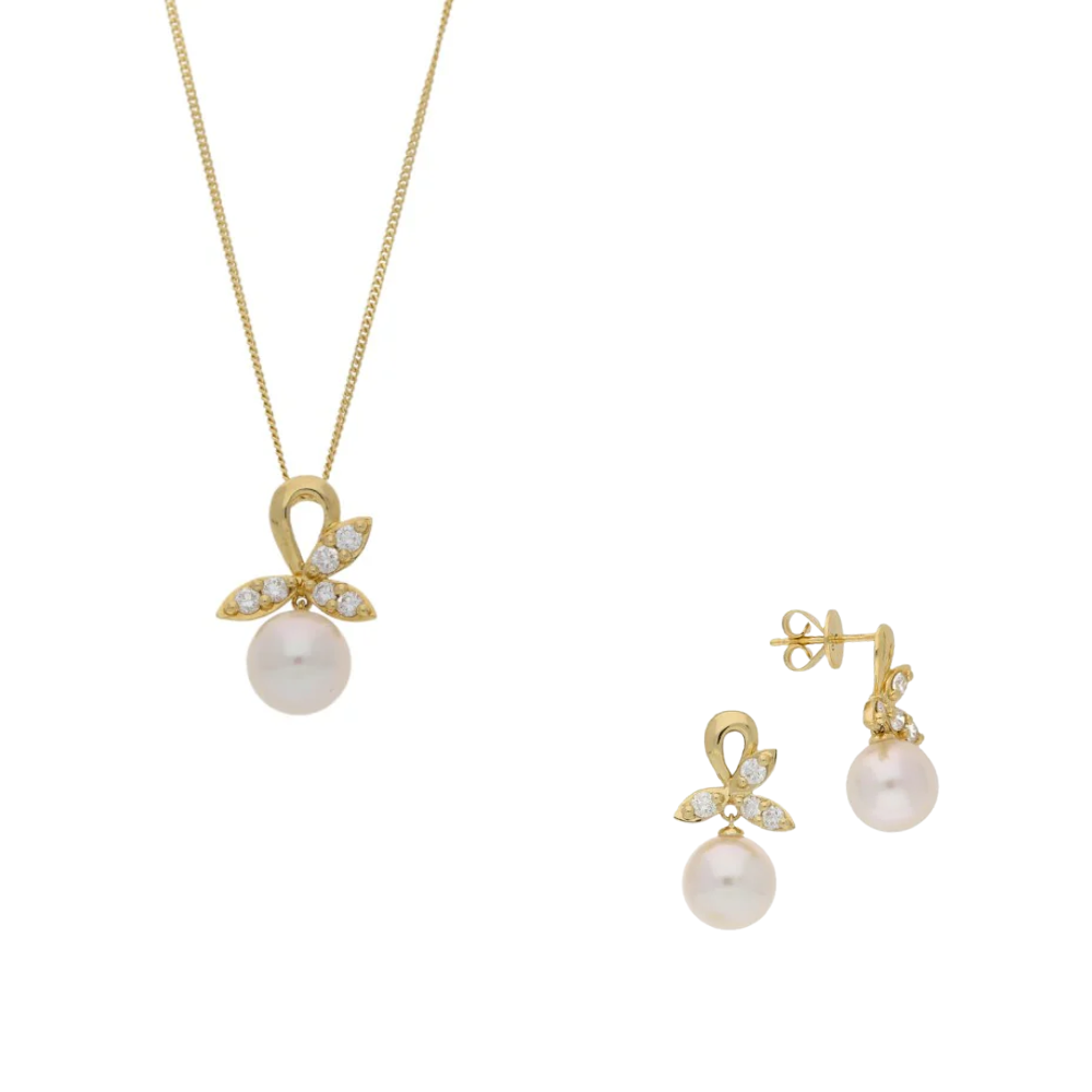 Gold jewelry set with pearl pendant and earrings on a white background
