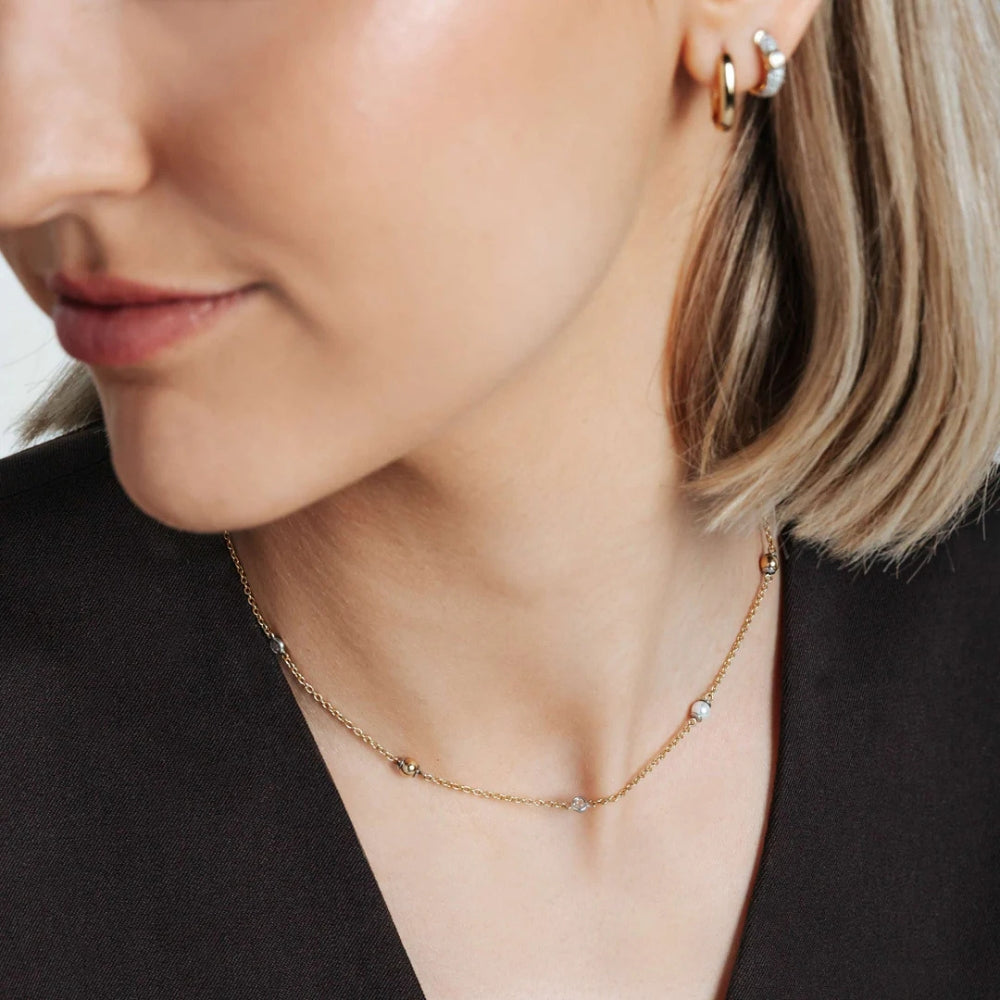 Close-up of a woman wearing a gold necklace.