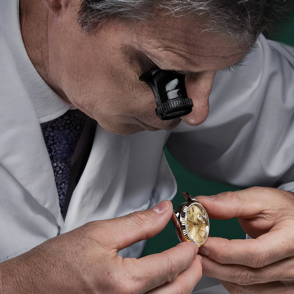 A man with an optical glass lens in the quality process of Rolex watches
