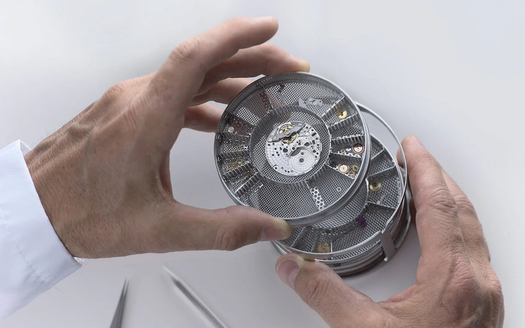 Hands holding a stack of small Rolex pieces